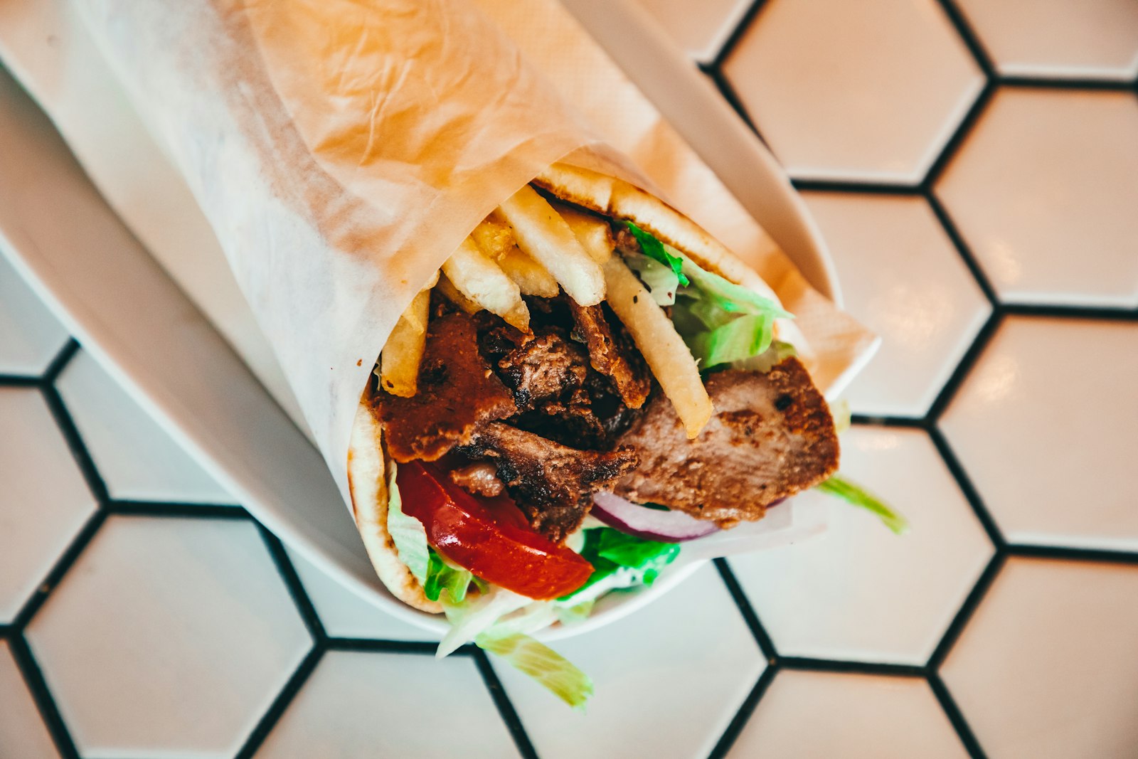 Frisch gerollter Dürüm Döner mit Pommes, Tomaten und Salat